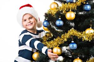 criança feliz com um presente perto da árvore de natal foto
