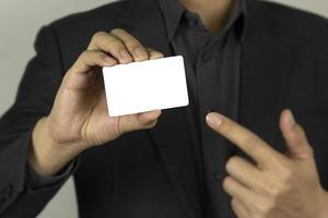 um empresário segurando o design de cartão de identificação simulado branco foto