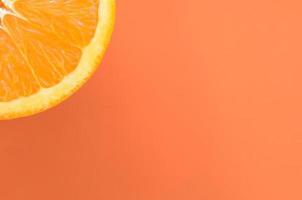 vista superior de uma fatia de fruta laranja sobre fundo brilhante na cor laranja. uma imagem de textura cítrica saturada foto