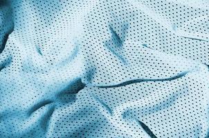 fundo de textura de tecido de roupas esportivas. vista superior da superfície têxtil de pano de nylon poliéster azul claro. camisa de basquete colorida com espaço livre para texto foto