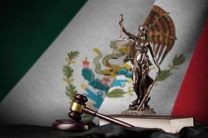 bandeira do méxico com a estátua da senhora justiça, constituição e juiz martelo na cortina preta. conceito de julgamento e culpa foto