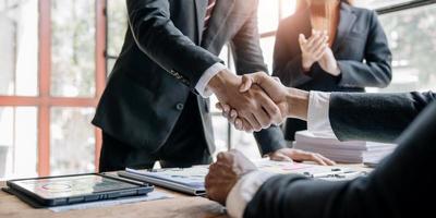 empresários apertando as mãos, terminando a reunião, etiqueta empresarial, parabéns, conceito de fusão e aquisição foto