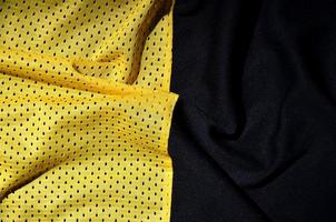 fundo de textura de tecido de roupas esportivas. vista superior da superfície têxtil de pano de nylon poliéster amarelo. camisa de basquete colorida com espaço livre para texto foto