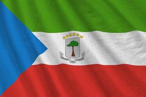 bandeira da guiné equatorial com grandes dobras acenando de perto sob a luz do estúdio dentro de casa. os símbolos oficiais e cores no banner foto