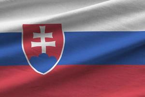 bandeira da eslováquia com grandes dobras acenando de perto sob a luz do estúdio dentro de casa. os símbolos oficiais e cores no banner foto
