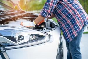 Abra o sistema do motor mecânico do capô para verificar e reparar danos ao acidente de carro. foto