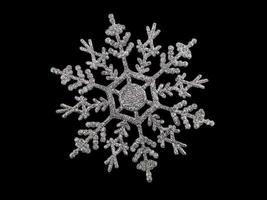 floco de neve prata brilhante sobre fundo preto isolado. natal, ano novo. espaço de cópia foto