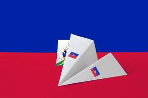 bandeira do haiti retratada no avião de papel origami. conceito de artes artesanais foto