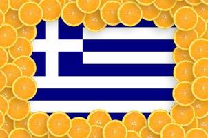 bandeira da grécia no quadro de fatias de frutas cítricas frescas foto