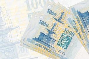 1000 notas de forint húngaro encontram-se na pilha no fundo da grande nota semitransparente. apresentação abstrata da moeda nacional foto