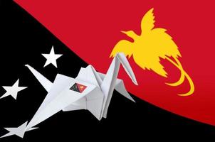 bandeira de papua nova guiné retratada na asa de guindaste de origami de papel. conceito de artes artesanais foto
