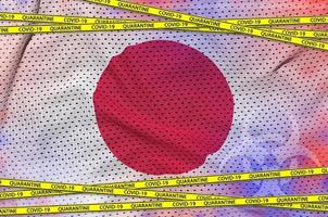 bandeira do japão e fita amarela de quarentena covid-19. conceito de vírus coronavírus ou 2019-ncov foto