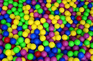 muitas bolas de plástico coloridas em uma piscina infantil em um playground. padrão de close-up foto