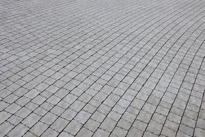 lajes de pavimentação de cor cinza na calçada da rua pedonal. padrão de paralelepípedos áspero com muitas pedras em forma de quadrado foto