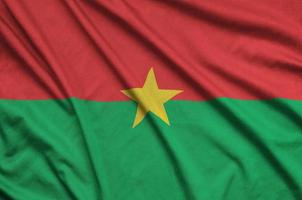 a bandeira de burkina faso é retratada em um tecido esportivo com muitas dobras. bandeira da equipe esportiva foto