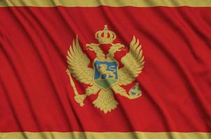 a bandeira de montenegro é retratada em um tecido esportivo com muitas dobras. bandeira da equipe esportiva foto