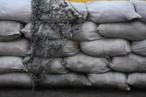 fundo de muitos sacos de areia sujos para defesa contra inundações. barricada protetora de sacos de areia para uso militar. belo bunker tático foto