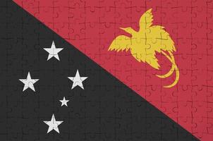 a bandeira de papua nova guiné é retratada em um quebra-cabeça dobrado foto