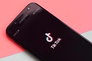 aplicativo tiktok na tela do smartphone samsung em fundo pastel. tiktok é um popular serviço de rede social de compartilhamento de vídeo de propriedade da bytedance foto