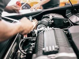 close-up de um homem trabalhando em um motor de automóvel foto