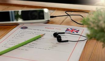 teste de escuta de inglês na mesa de madeira foto