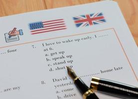 teste de inglês com caneta na mesa de madeira na aula foto