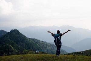 mulher jovem viajante com mochila elegante olhando para a incrível vista para as montanhas. curtindo a natureza, relaxe, prazer. foto