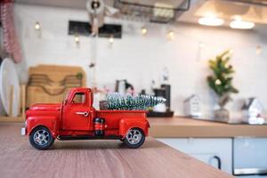 um carro retrô vermelho com uma árvore de natal decora a cozinha festiva para o natal. decoração de casa, clima festivo, ano novo foto