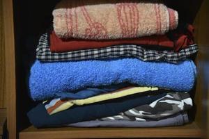 roupas íntimas e roupas guardadas no armário. roupas colocadas em uma prateleira no armário. foto