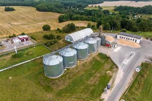 vista aérea em fileiras de elevador de celeiro de silos agro com linha de limpeza de sementes em enorme planta de fabricação de agro-processamento para processamento de limpeza de secagem e armazenamento de produtos agrícolas foto