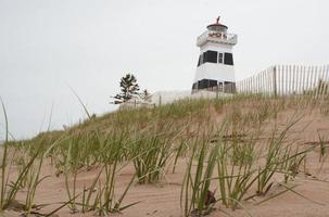 farol príncipe edward island com dunas de areia foto