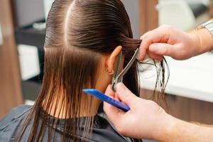 cabeleireiro penteia o cabelo da jovem foto