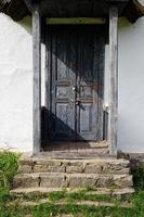 velha porta resistida na parede de madeira de uma antiga cabana foto