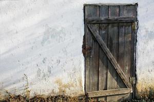 porta de madeira velha em uma parede de pedra velha foto