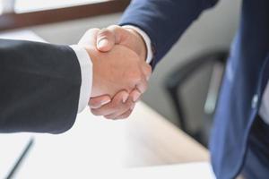 dois homens de negócios apertam as mãos para cooperação empresarial foto