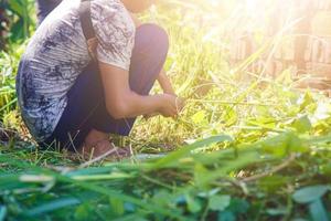 um agricultor cortando as ervas daninhas com uma foice foto