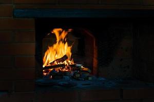crista de chama na queima de madeira na lareira. queima de lenha em um fogão russo. foto