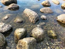 grande redondo belos paralelepípedos de pedras naturais na água, mar, lago, rio. fundo, textura foto