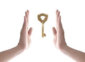 a chave para o sucesso, mão segurando a chave isolada no branco foto