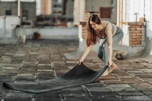 mulher preparando tapete de ioga para treinamento ao ar livre foto