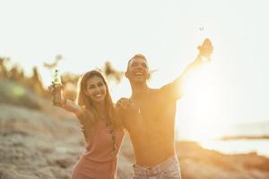 casal curtindo o pôr do sol na praia foto