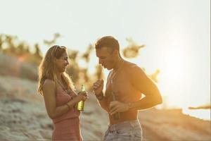 casal curtindo o pôr do sol na praia foto