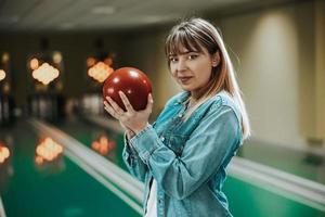 garota se divertindo em uma pista de boliche foto