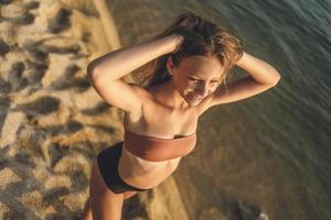 menina adolescente desfrutando na praia foto