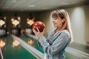 jovem se divertindo em uma pista de boliche foto