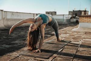 mulher fazendo ioga ao ar livre em um terraço foto