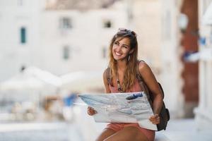 mulher com um mapa explorando uma cidade estrangeira enquanto aproveita as férias de verão foto