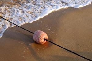 corda de cânhamo com bóias na praia da cidade foto