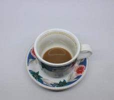 restos de café com creme de leite em uma xícara, escorridos para o fundo da bebida. vista do topo foto