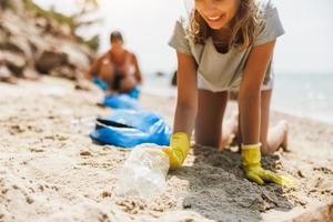 voluntário adolescente limpa a praia foto